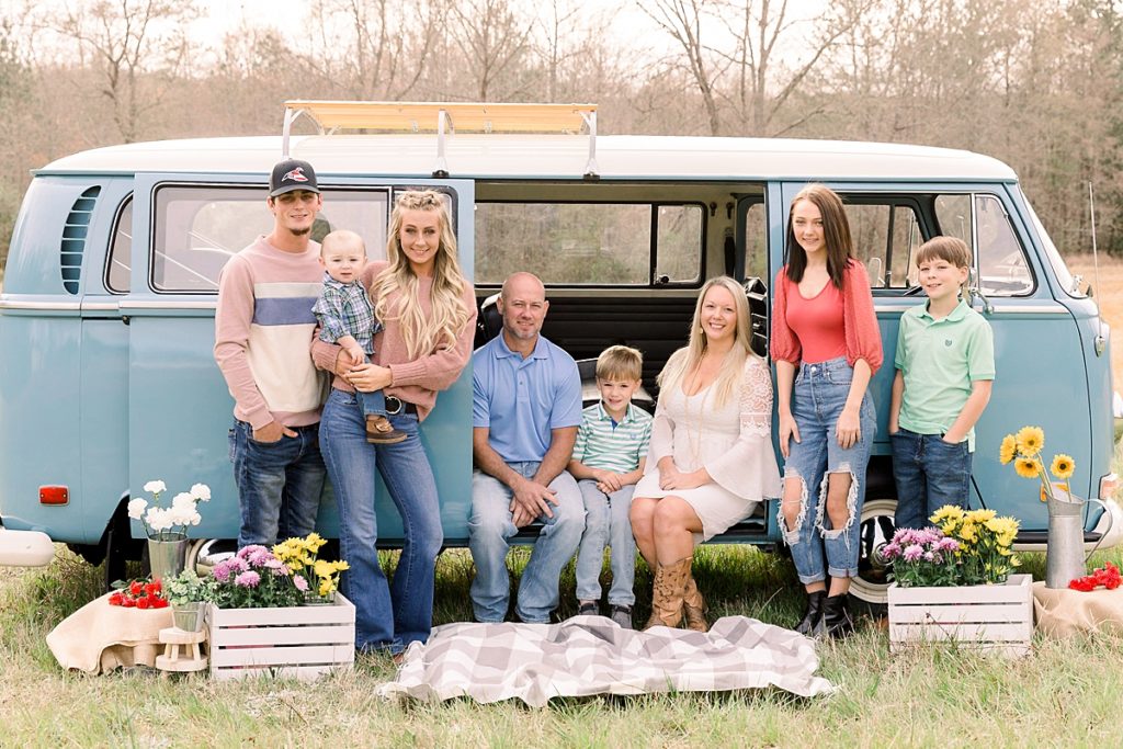 Family poses with blue VW Bus for spring portraits