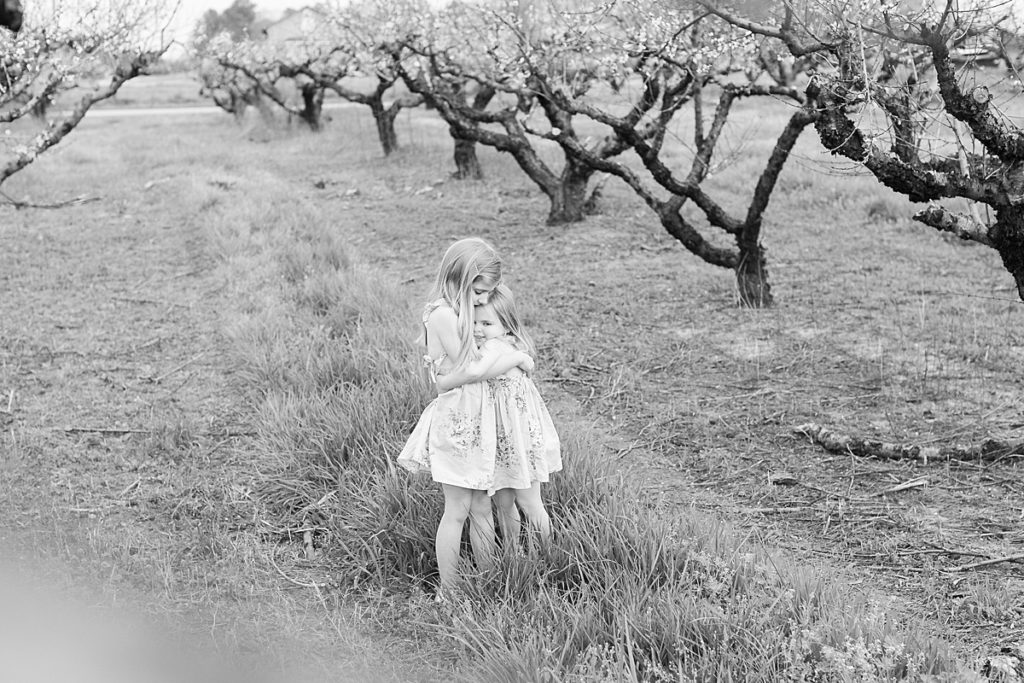 Children hug in peach trees at Gregg Farms in Concord GA